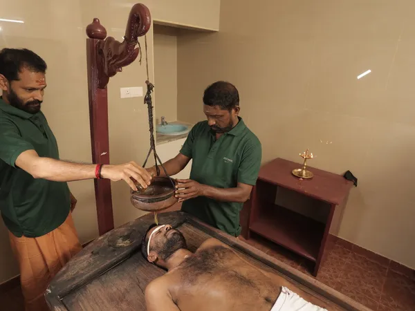 Dhanyamla Dhara warm fermented grain decoction stream therapy for rheumatoid arthritis and inflammatory back pain at Agasthya Kerala