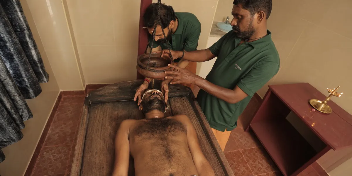 Shirodhara therapy - warm medicated oil being poured on forehead for stress relief
