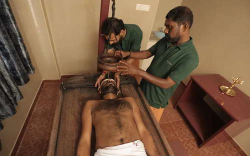 Shirodhara therapy - warm medicated oil being poured on forehead for stress relief