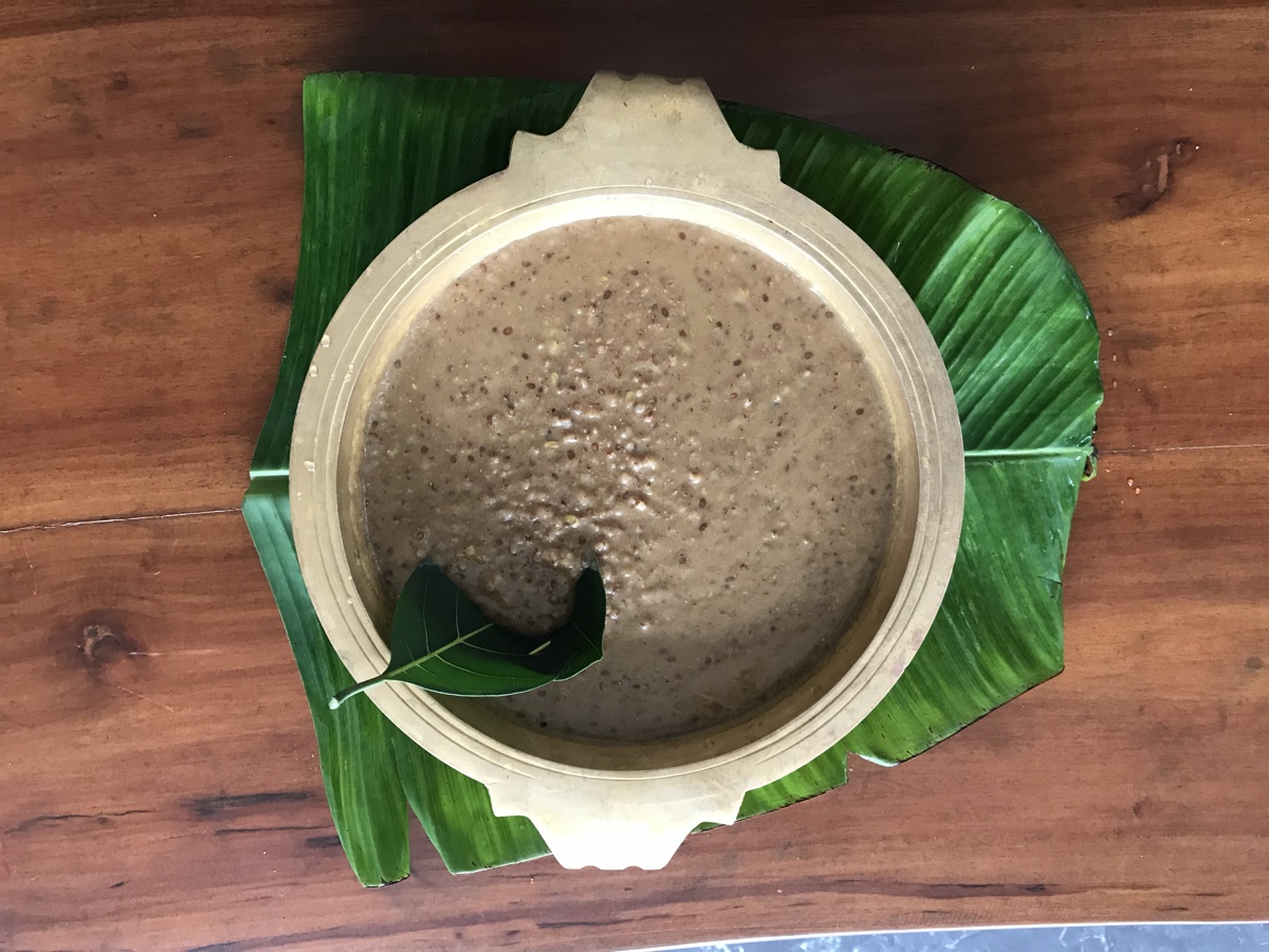 Karkidaka kanji, the medicated monsoon rice gruel, served in a brass uruli on a banana leaf at Agasthya Ayurvedic Hospital, Kerala
